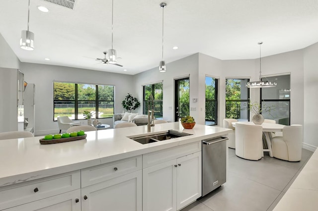 kitchen with hanging light fixtures, white cabinets, a sink, open floor plan, and recessed lighting