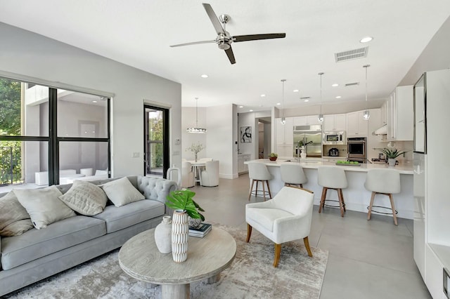living room with visible vents, ceiling fan, recessed lighting, and finished concrete floors
