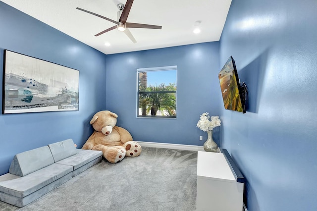 interior space featuring ceiling fan, baseboards, and carpet