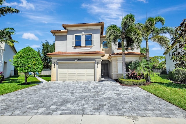 view of front facade featuring an attached garage, fence, stucco siding, a front lawn, and decorative driveway