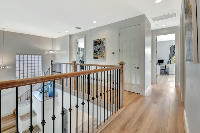 corridor featuring baseboards, recessed lighting, an upstairs landing, light wood-style floors, and visible vents