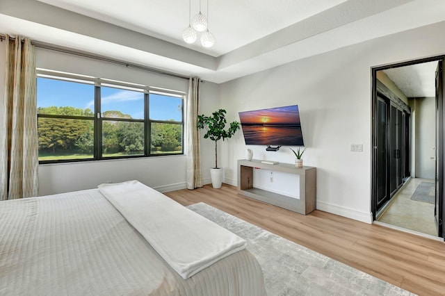 bedroom with baseboards, a chandelier, and wood finished floors