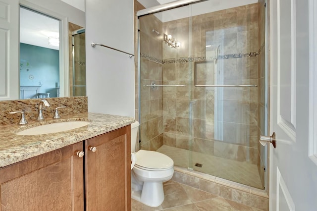 bathroom with a shower stall, tile patterned floors, vanity, and toilet