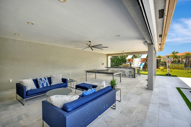 view of patio / terrace featuring fence, a playground, an outdoor hangout area, and a ceiling fan