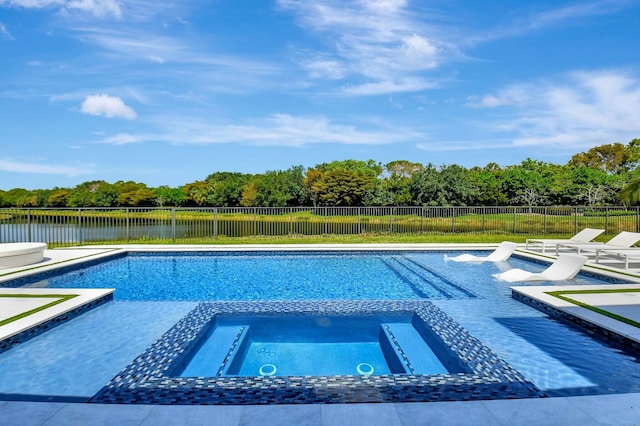 view of swimming pool with a water view, a pool with connected hot tub, a patio, and a fenced backyard