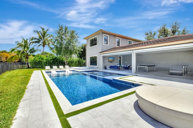 view of pool with a yard, a pool with connected hot tub, a fenced backyard, a patio, and an outdoor hangout area