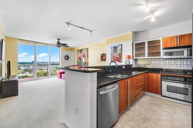 1551 N Flagler Dr Unit 1509, West Palm Beach, FL 33401 - kitchen with a peninsula, floor to ceiling windows, appliances with stainless steel finishes, a sink, and decorative backsplash