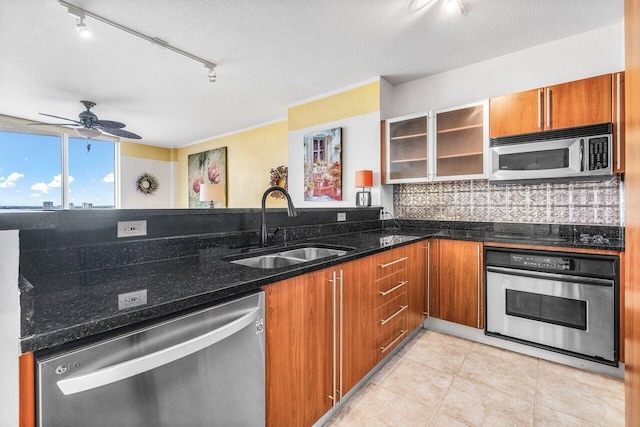 1551 N Flagler Dr Unit 1509, West Palm Beach, FL 33401 - kitchen with dark stone countertops, a sink, stainless steel appliances, brown cabinets, and backsplash