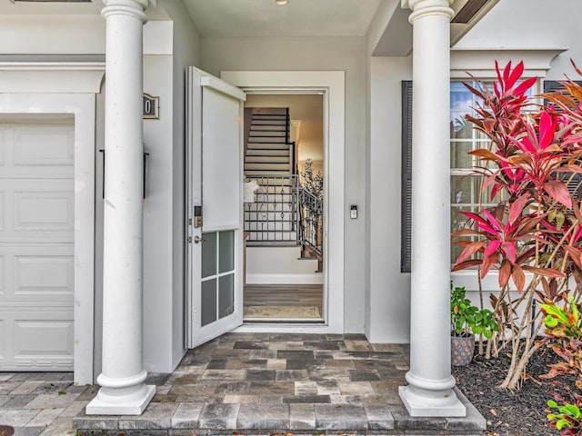 property entrance featuring a garage and stucco siding
