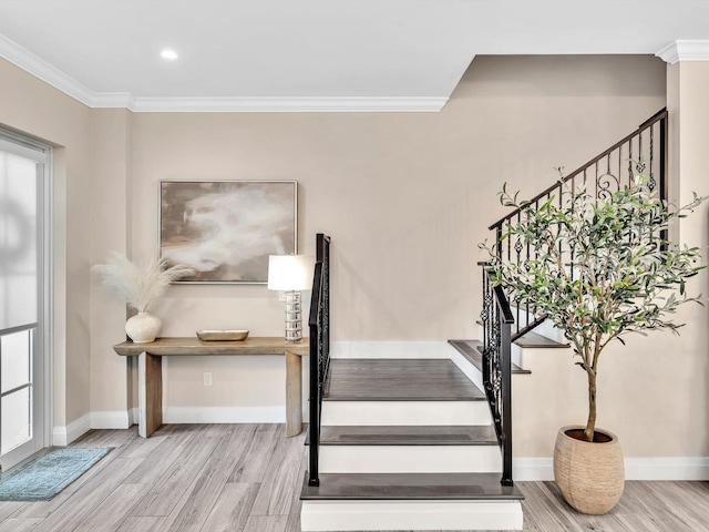 stairs with wood finished floors, baseboards, ornamental molding, and recessed lighting