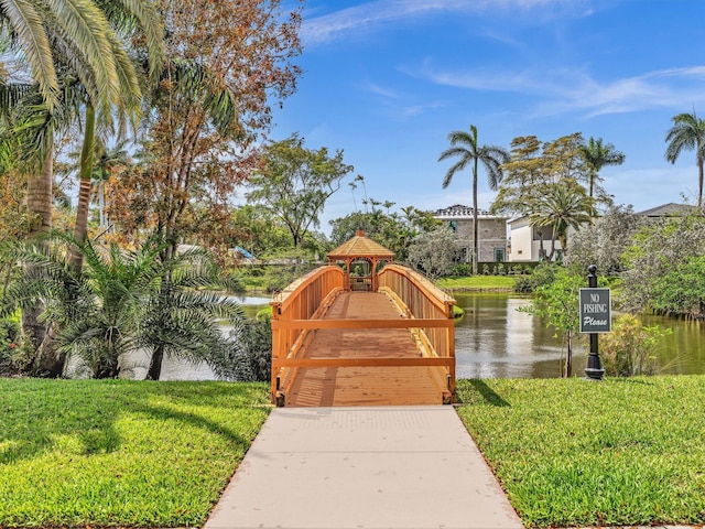 surrounding community with a lawn and a water view