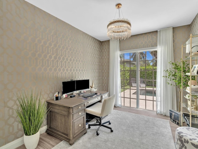 office area featuring a chandelier, wallpapered walls, baseboards, and light wood-style flooring