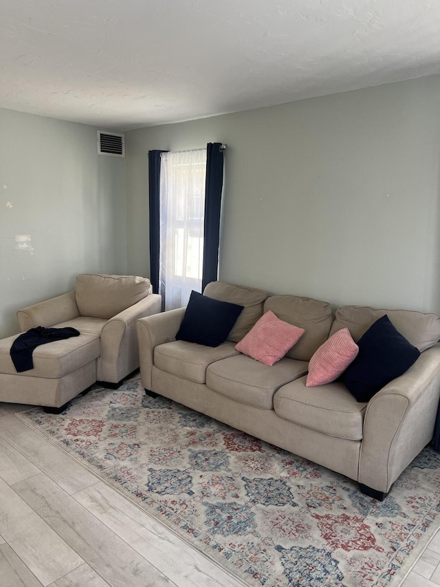 living area featuring wood finished floors and visible vents