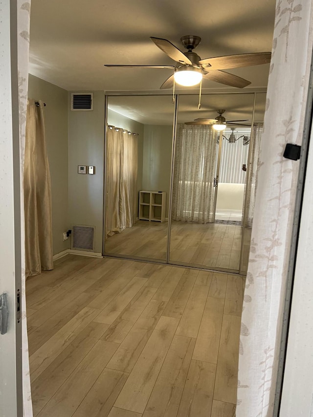 hall with visible vents and wood finished floors