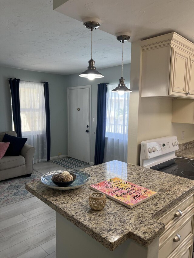 kitchen with electric range, light wood-type flooring, light stone counters, decorative light fixtures, and open floor plan