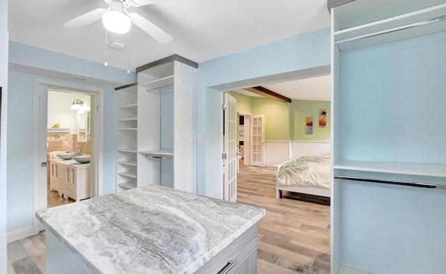 walk in closet featuring light wood finished floors and a ceiling fan