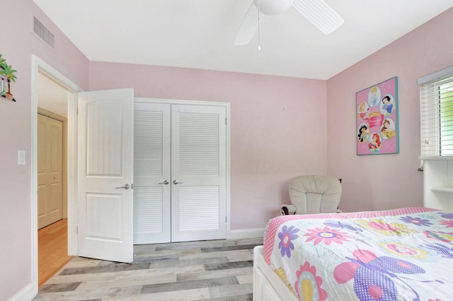 bedroom featuring ceiling fan, light wood-type flooring, a closet, visible vents, and baseboards