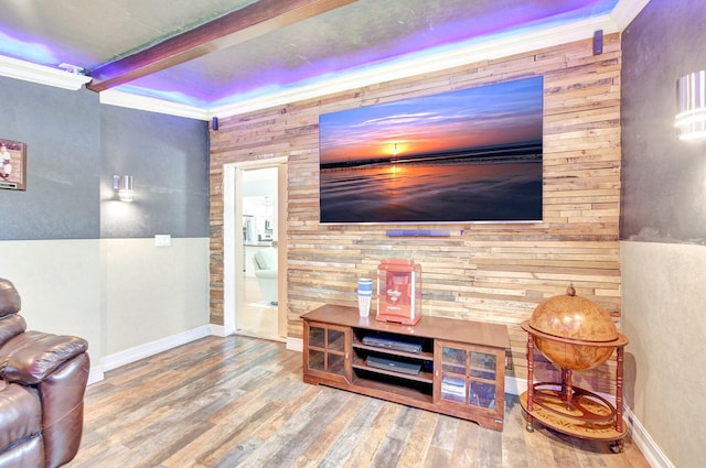living room with crown molding, wood finished floors, wood walls, and beam ceiling
