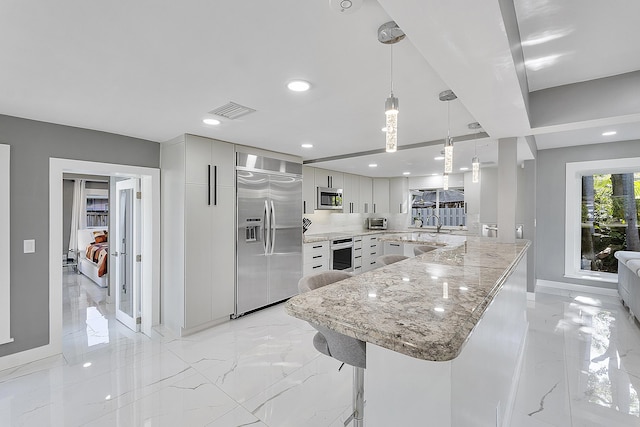 1900 NE 16th Ter, Fort Lauderdale, FL 33305 - kitchen featuring modern cabinets, a peninsula, visible vents, appliances with stainless steel finishes, and baseboards