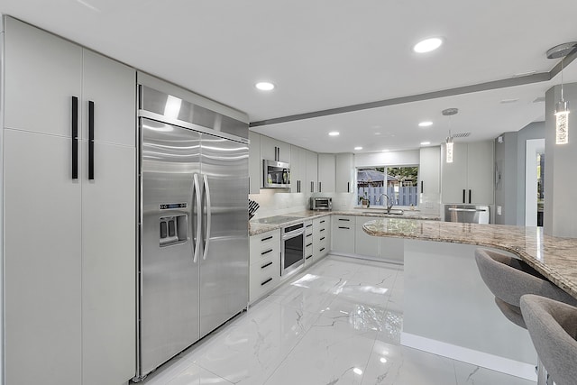 1900 NE 16th Ter, Fort Lauderdale, FL 33305 - kitchen with marble finish floor, a sink, light stone counters, and appliances with stainless steel finishes