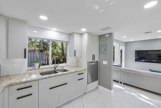 1900 NE 16th Ter, Fort Lauderdale, FL 33305 - kitchen featuring light stone countertops, white cabinetry, visible vents, a sink, and backsplash