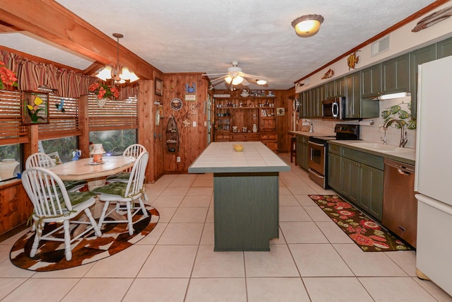 kitchen featuring appliances with stainless steel finishes, a sink, light countertops, a kitchen island, and visible vents