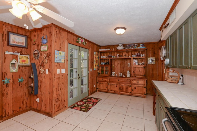 interior space featuring wood walls, light tile patterned floors, and electric range oven