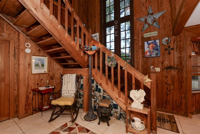 stairway featuring tile patterned flooring, french doors, and wood walls