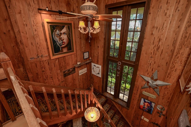 staircase featuring wooden walls