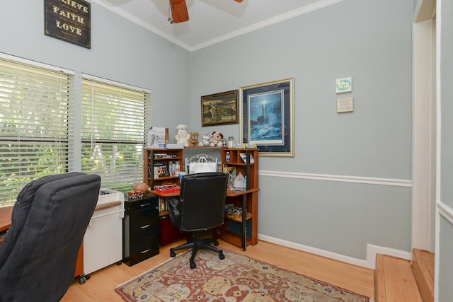 home office with light wood-style floors, ornamental molding, a ceiling fan, and plenty of natural light