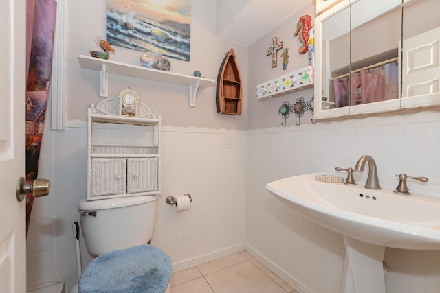 full bathroom with toilet, baseboards, a sink, and tile patterned flooring