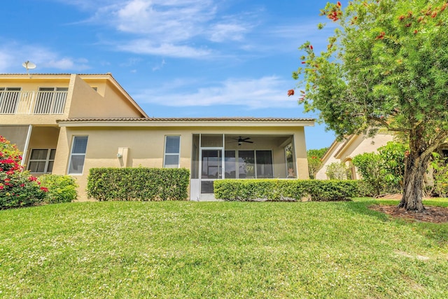 9225 Wentworth Ln, Port Saint Lucie, FL 34986 - back of house with ceiling fan, a sunroom, a lawn, and stucco siding