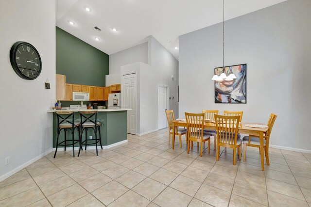 9225 Wentworth Ln, Port Saint Lucie, FL 34986 - dining area with an inviting chandelier, high vaulted ceiling, light tile patterned floors, visible vents, and baseboards