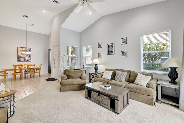 9225 Wentworth Ln, Port Saint Lucie, FL 34986 - carpeted living room with high vaulted ceiling, a ceiling fan, visible vents, tile patterned floors, and baseboards