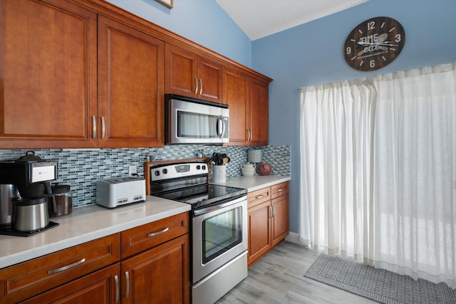1103 Aviary Rd, Wellington, FL 33414 - kitchen with light wood-style floors, light countertops, decorative backsplash, and appliances with stainless steel finishes