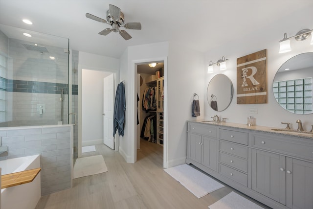 1103 Aviary Rd, Wellington, FL 33414 - full bathroom featuring ceiling fan, wood finished floors, a sink, a stall shower, and double vanity