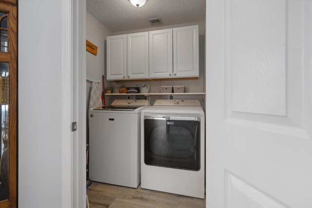1103 Aviary Rd, Wellington, FL 33414 - laundry room featuring visible vents, light wood-style floors, a textured ceiling, independent washer and dryer, and cabinet space
