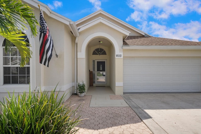 1103 Aviary Rd, Wellington, FL 33414 - doorway to property with roof with shingles, driveway, a garage, and stucco siding
