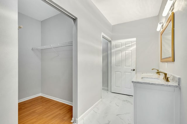 bathroom featuring baseboards, marble finish floor, and vanity
