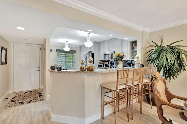 5749 Gemstone Ct Unit 107, Boynton Beach, FL 33437 - kitchen with crown molding, a peninsula, appliances with stainless steel finishes, and light wood-style floors
