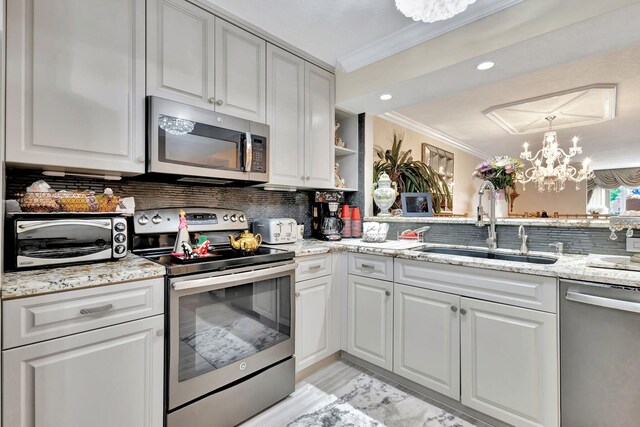 5749 Gemstone Ct Unit 107, Boynton Beach, FL 33437 - kitchen featuring crown molding, a sink, decorative backsplash, an inviting chandelier, and appliances with stainless steel finishes