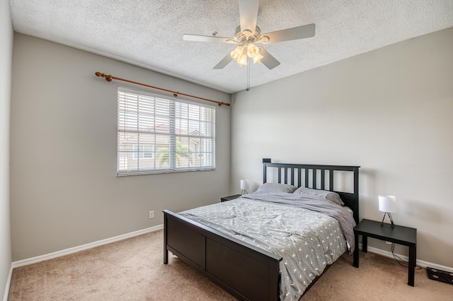 carpeted bedroom with baseboards, ceiling fan, and a textured ceiling