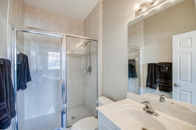 bathroom featuring toilet, a stall shower, and vanity