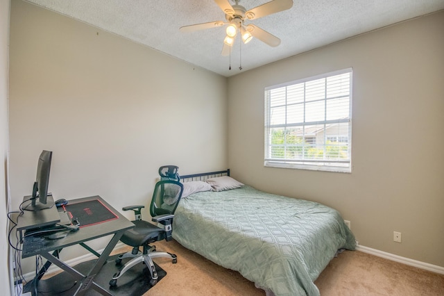 carpeted bedroom with baseboards, a textured ceiling, and a ceiling fan