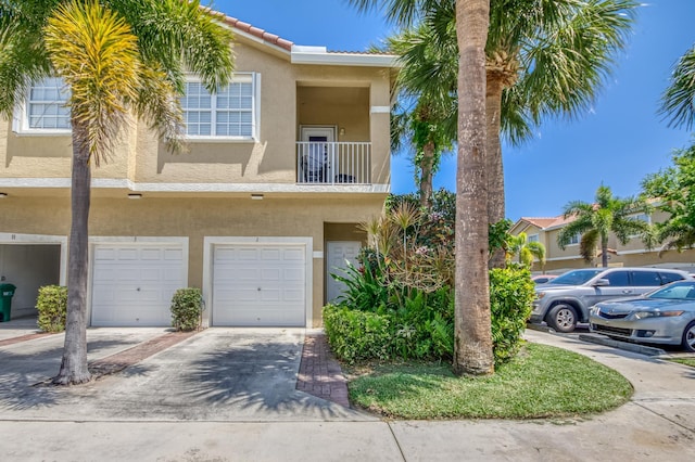 112 Lighthouse Cir Unit J, Tequesta, FL 33469 - view of property featuring stucco siding, driveway, and a garage