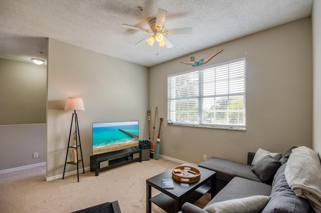 living room featuring a textured ceiling, ceiling fan, baseboards, and carpet floors