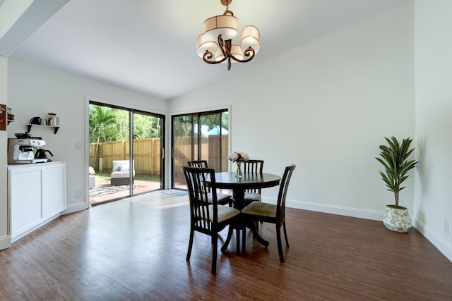 dining space with dark wood-type flooring, a notable chandelier, baseboards, and lofted ceiling