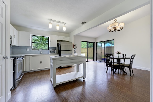 kitchen with appliances with stainless steel finishes, an inviting chandelier, visible vents, and plenty of natural light