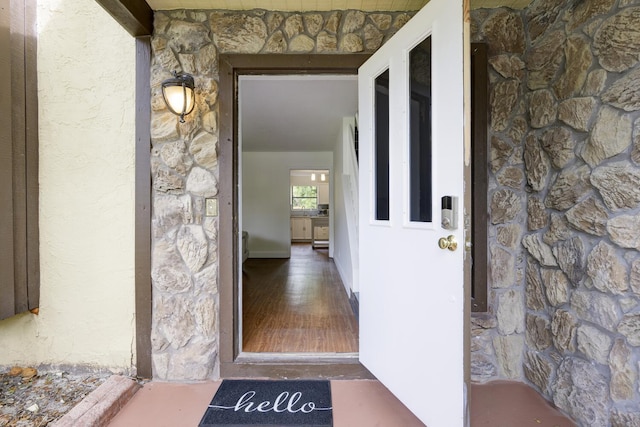 property entrance with stucco siding and stone siding