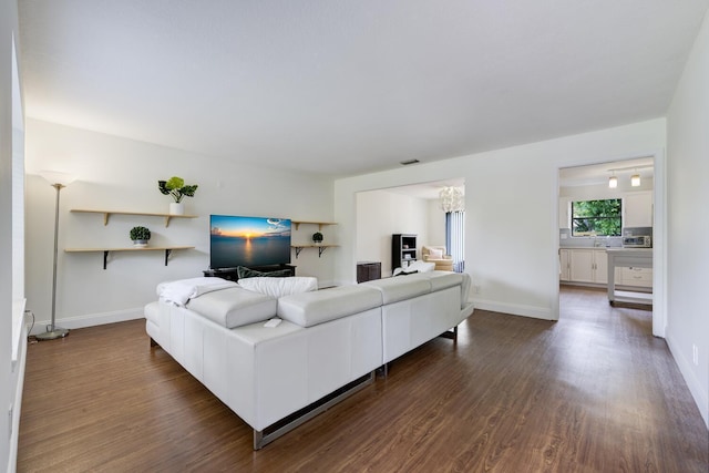 living area featuring dark wood-type flooring and baseboards